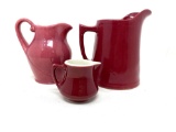 Three vintage cranberry stoneware pitchers