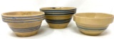 Three antique crock bowls with blue lines
