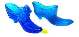 Two vintage blue glass shoes