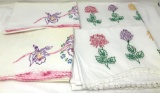 Four embroidered pillowcases with crocheted edging
