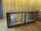 APPROXIMATELY 12' LONG WOODEN AND GLASS DISPLAY CASE. 