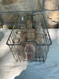 METAL BASKET FILLED W/ VINTAGE MIIL BOTTLES INCLUDING CREAM TOPS