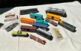 LOT OF VINTAGE TOY TRAIN CARS INCLUDING 2 H.O. ENGINES, 1 LARGER LIONEL TANK CAR & MORE