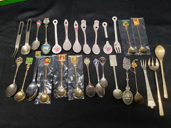 Collector spoons. Korea. Saipan. Canada. Silver and gold look. Some porcelain look spoons and fork.