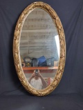 Heavy vintage wall mirror with gold leaf frame.