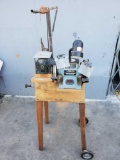 Delta 6 in bench grinder with lamp and 1 in belt sander mounted on peadastool with wheels.