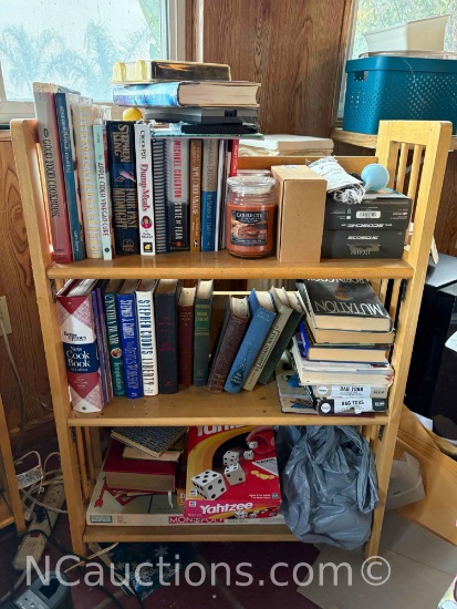 bookshelf and everything it includes books, games, candles, and Mt Misery Rd