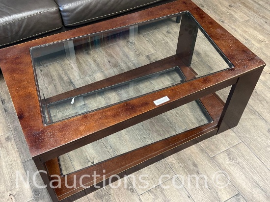 Brown wooden coffee table featuring an inset glass top upstairs