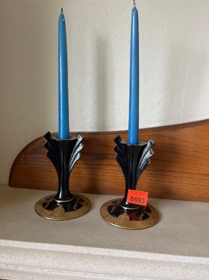 Two blue candles, and black and gold candleholders
