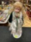 Vintage Porcelain Little Girl Doll with White, Green, and Gold Outfit and Stand