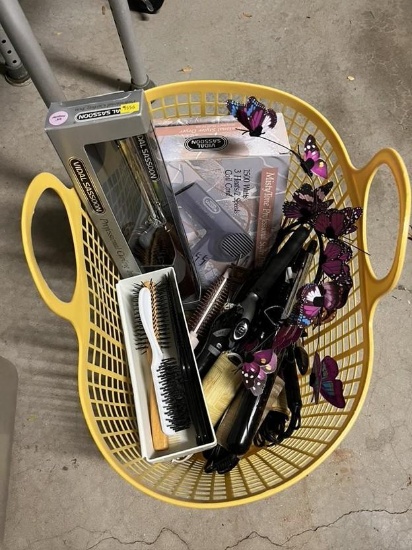 Basket of curling irons, blow dryer, and combs