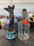Art deco style sculpture of a woman and a mason jar