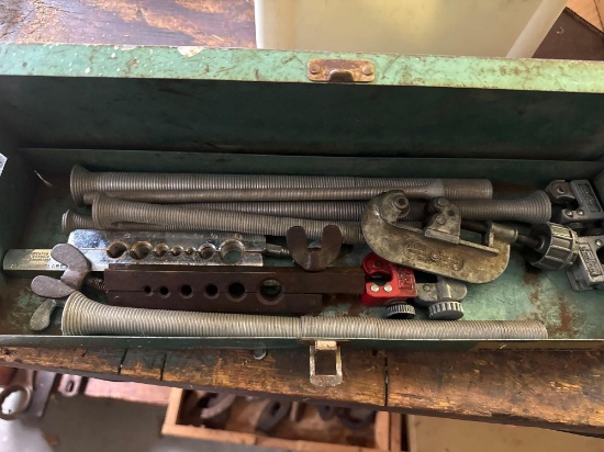 Metal pieces and pipe cutter in green toolbox