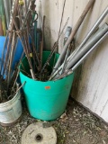 Green barrel with misc poles *BUYER IS RESPONSIBLE FOR LOADING*