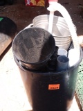 Small black trashcan with funnel and metal canister and other miscellaneous items