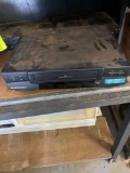 VHS player and weight and wall decor