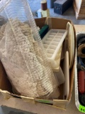 Multiple doilies, plastic egg holders, plastic ice cube trays, two miscellaneous Tupperware with lid