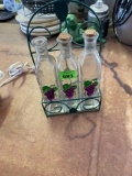 set of 3 glass bottles with grape pattern in metal carry caddy