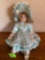 Porcelain doll and blue with pearl like necklace
