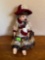Porcelain doll with hat and rabbit and a pouch