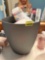 Wastebasket, full of first aid items, soap, comb, and more