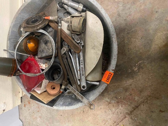 Metal pan with red tail light lense, orange turn signal, wrenches, and other various items