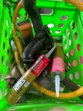 Green tote with liquid nails, hammer, flexible gas pipe and more