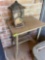 Metal table and broken lantern bird feeder on back porch