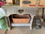 Wooden table and planter, items on top not included. On back porch