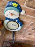 Outdoor snowman temperature gauge on back porch