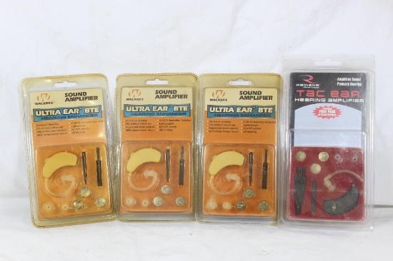 Four sound amplifier hearing aids. Three Walker's and one Radians Tac-Ear. New in original packages.