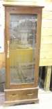 One standing glass fronted and wood gun case with brass handle and lock with key has bottom drawer