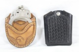 One brown leather handcuff pouch with handcuffs and one black Bianchi double 45 ACP magazine holder.