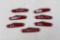 Seven Coca-Cola advertising knives with 2.5 inch single blades and red scales.