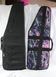 Two nylon soft sided, padded AR-15 rifle cases. One is black and one is pink and purple camo. Both
