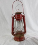 One red kerosene lamp lantern. Used in fair to poor condition. Appears to work as it should.