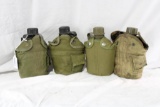 Four green military canteens with nylon covers. Used. one has a busted cap.