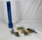 One blue Mag-Lite, one 20 ga choke tube and two plastic fishing jigs.