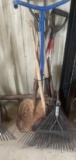 Various yard tools including several leaf rakes with no handles, shovels and weeder