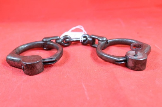 One pair of antique iron handcuffs with key