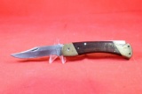 Schrade+ USA folding lockback with 3.75 inch single blade. Brass & wood handle. Used, showing wear.