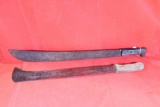 Two machetes. First has large curved 19.0 inch blade. Second has 22.0 inch blade. Neither has a
