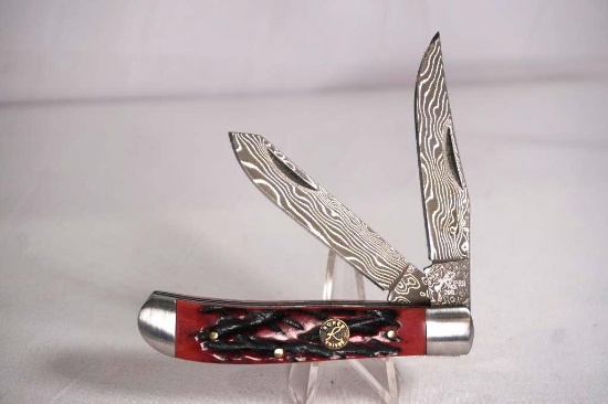 Roper brand trapper with 2.75 inch Damascus steel blades. Jigged red bone scales. Appears as new.