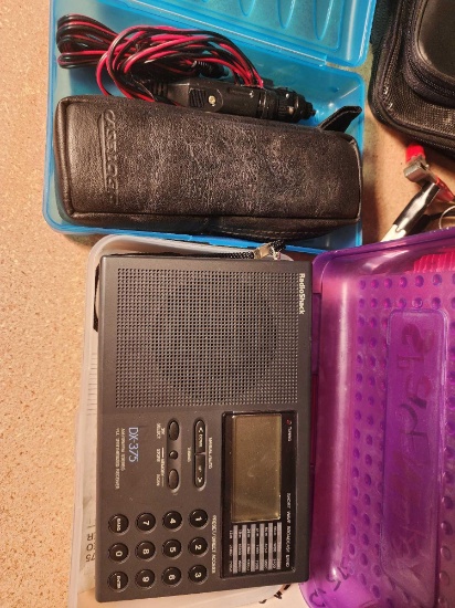 Blue plastic box with a Magellan GPS 315, with two car lighter plugs for charging in case and a
