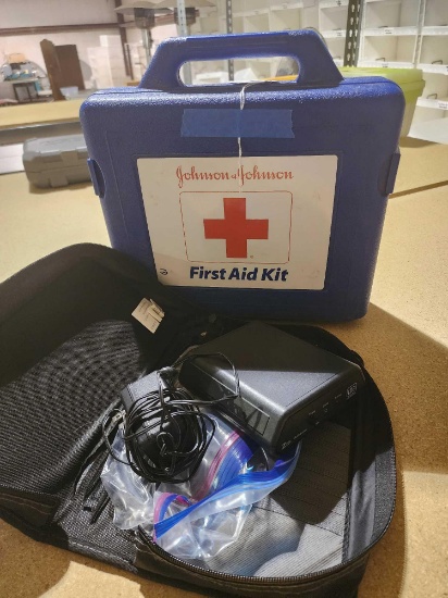 Blue plastic J&J first aid kit with some supplies and, a radio tuner? in nylon case.