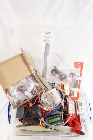 One clear plastic tub with miscellaneous RC plane parts.