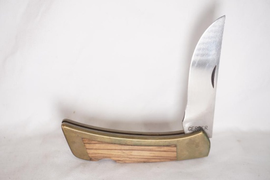 One Gerber folding hunter with brass and wood handle. 4" blade, and leather sheath. Used, but in