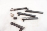 Two 1911 barrel bushings and five 1911 barrels, four Colt 45 auto, one unknown 45 ACP,
