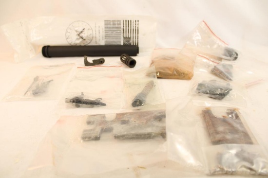 Bag containing an A2 buffer tube, muzzle break, unknown trigger assemblies, and other gun parts