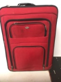 LARGE RED SUIT CASE ON WHEELS W/RETRCTABLE HANDLE